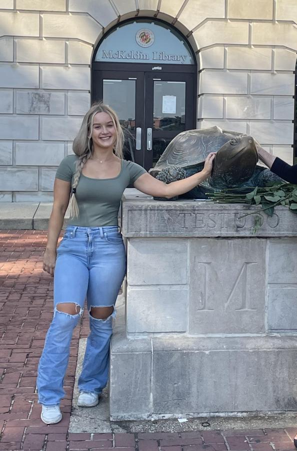 UMD student rubbing the bronze nose of a sculpture of Testudo - the school mascot. 